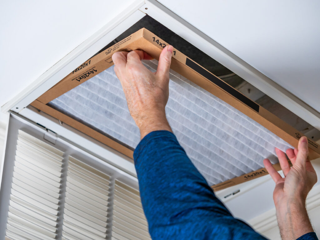 HVAC technician replacing a home air filter in Long Beach