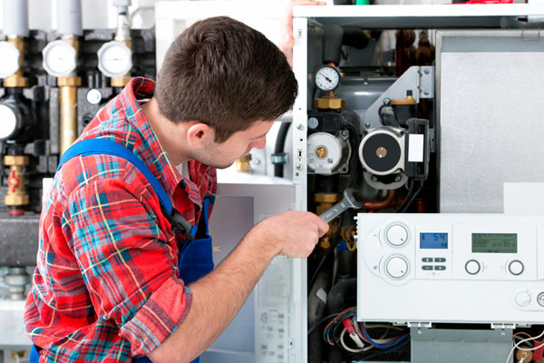 Heating technician repairing boiler controls in Long Beach
