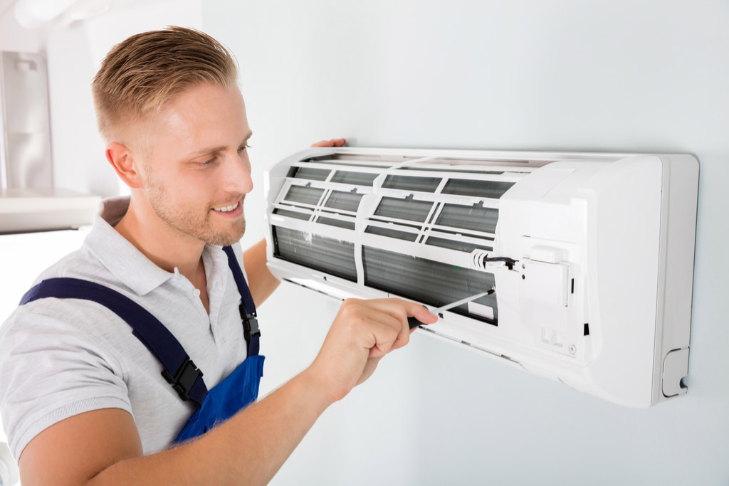 HVAC technician maintaining a ductless air conditioner in Long Beach