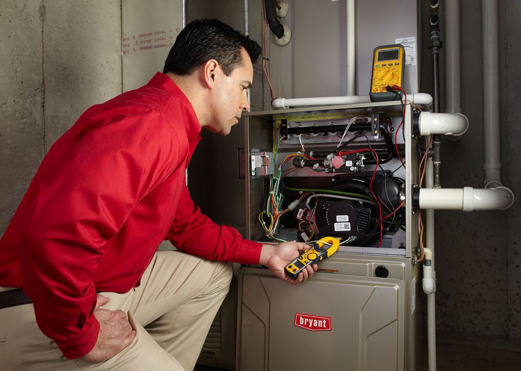 Heating technician diagnosing a furnace repair in Long Beach