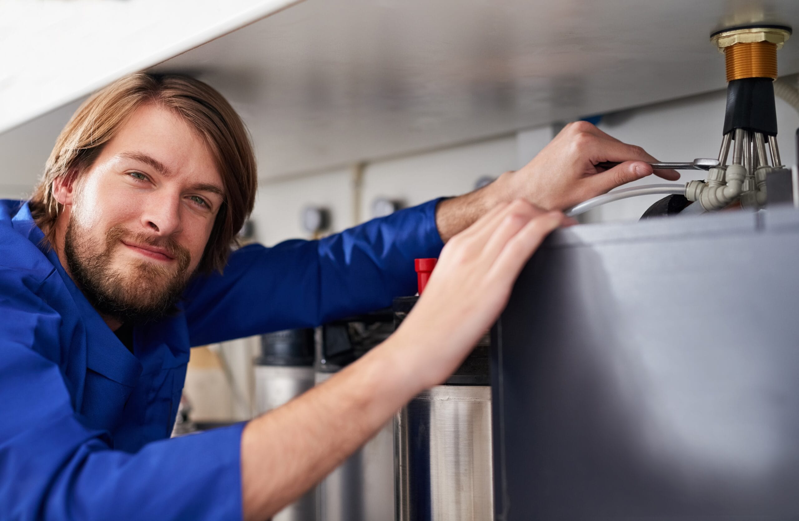 Technician servicing a residential water heater tank in Long Beach