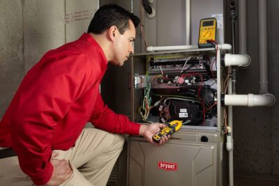 Heating technician diagnosing a furnace repair in Long Beach