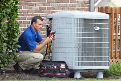 HVAC technician inspecting an outdoor AC unit in Long Beach